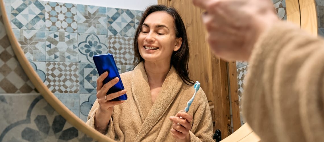 BLOG-Woman-brushing-teeth-looking-at-phone